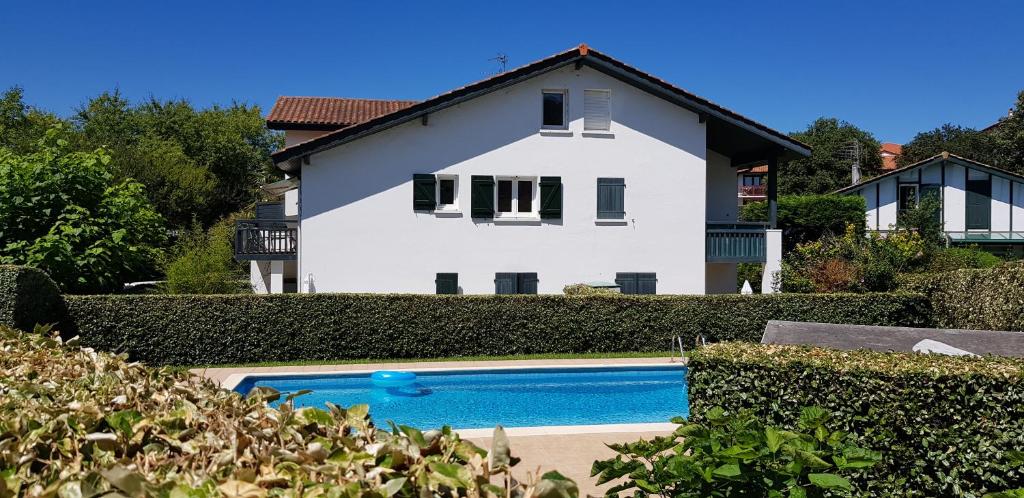 una casa blanca con piscina frente a ella en GUETHARY APPARTEMENT PLAIN PIED PROCHE PLAGE CENITZ en Guéthary