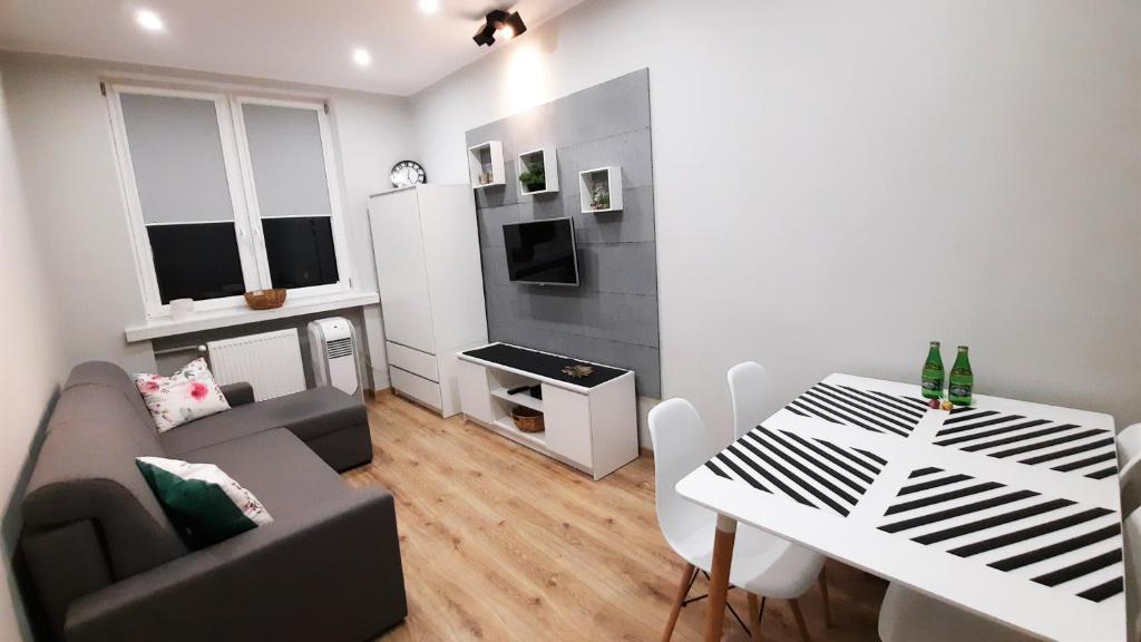 a small living room with a couch and a table at ALEJA PARK CZĘSTOCHOWA in Częstochowa