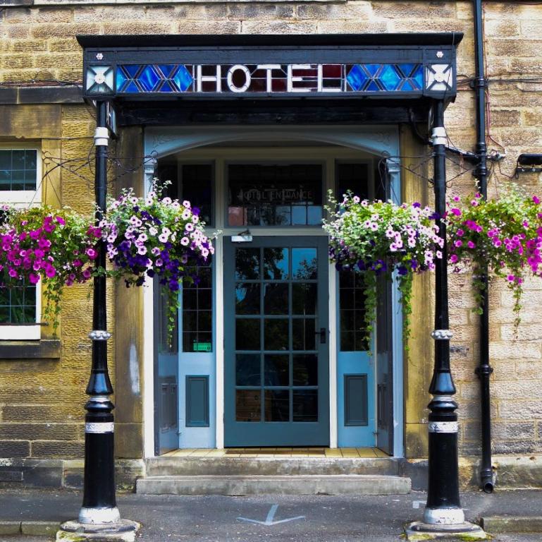 a hotel entrance with flowers in front of it at Newcastle House Rothbury in Rothbury