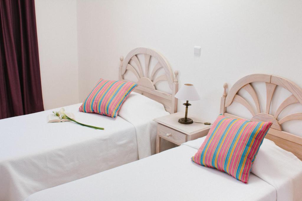 a bedroom with two beds and a table with a lamp at Dunas do Alvor - Budget in Alvor