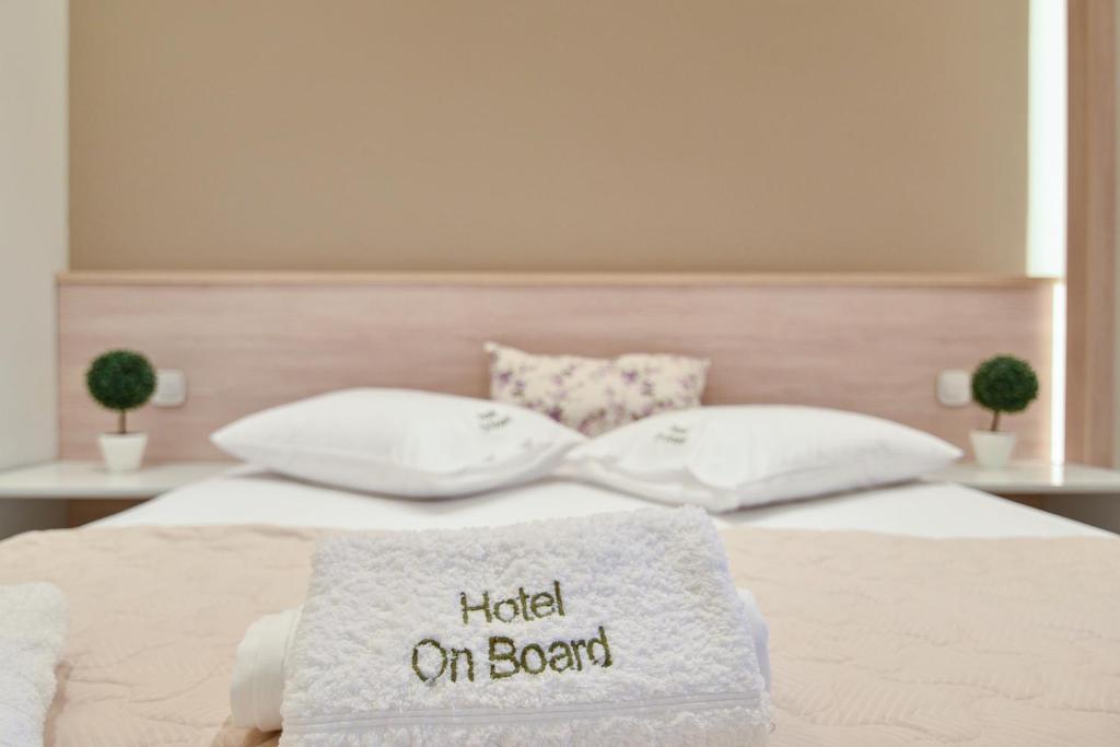 a bed with a blanket that reads hated on board at On Board Luxury Studios in Sarti