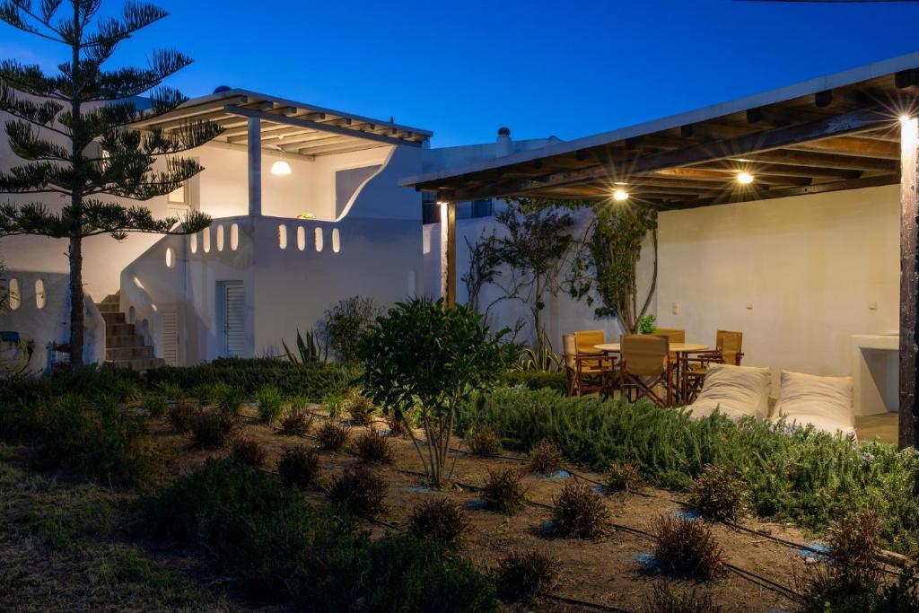 un cortile con mobili da giardino e pergolato di Drafies House a Mykonos Città