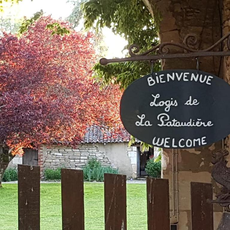 een bord op een hek voor een huis bij Le Logis de la Pataudière in Champigny-sur-Veude