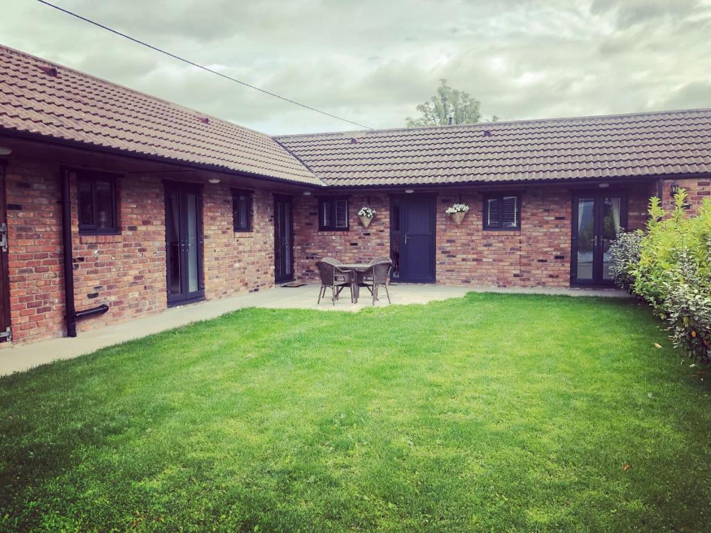 a brick house with a lawn in front of it at Boundary Cottage in Middleton