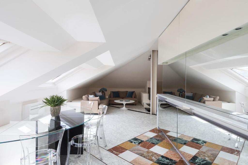 an attic living room with a glass table and chairs at Loft Cedro, by R Collection Apartments in Como