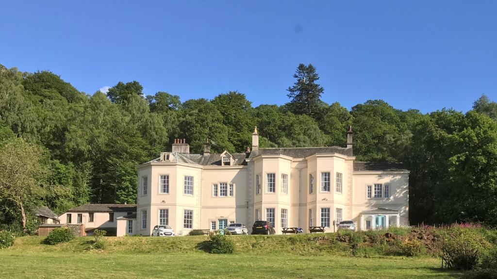 a large white house sitting on top of a field at Derwentwater Independent Hostel in Keswick