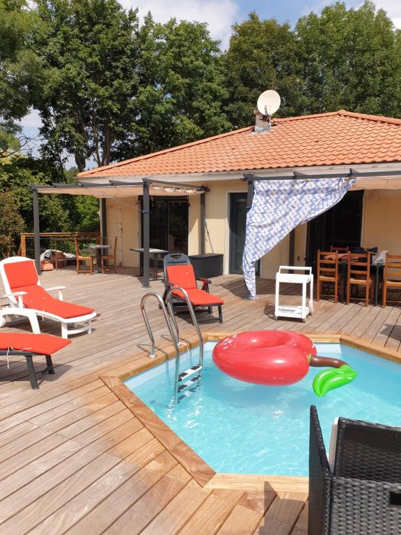 einen Pool mit Stühlen, einem Tisch und einer Terrasse in der Unterkunft Brigitte Carbonnel in Aydat