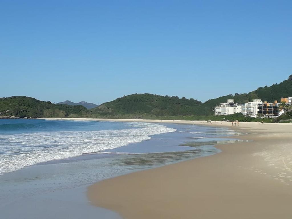 a view of a beach with buildings in the background at Vila de Sol in Bombinhas