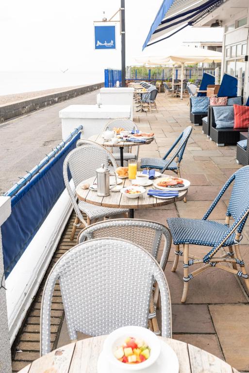 a table and chairs on a patio with a bowl of fruit at The Brudenell in Aldeburgh