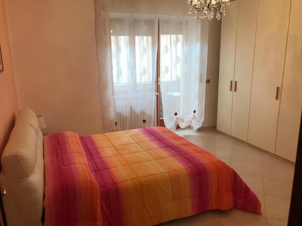 Lux Appartamento في Busso: غرفة نوم مع سرير وبطانية ملونة