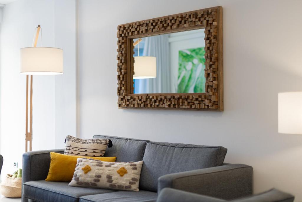 a living room with a blue couch and a mirror at Deisy Apartments in Puerto de Mogán