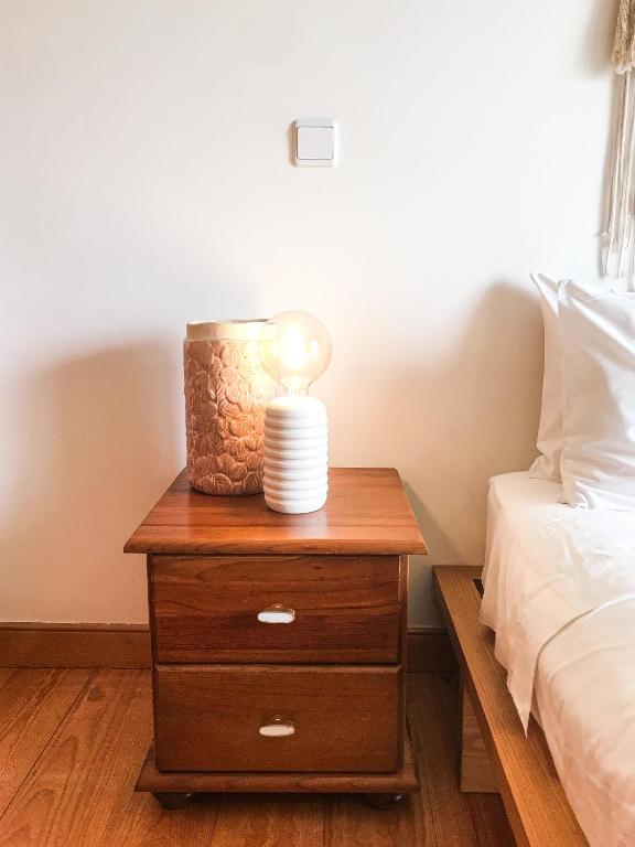 a nightstand with a lamp on it next to a bed at Quinta Amarela - B&B in Nazaré