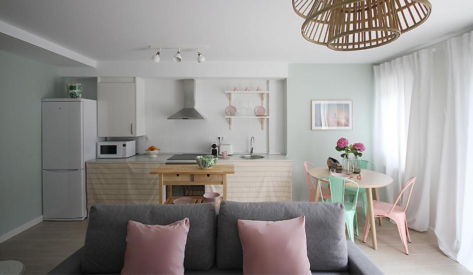 a living room with a couch and a kitchen at Apartamento de diseño en el Sardinero in Santander