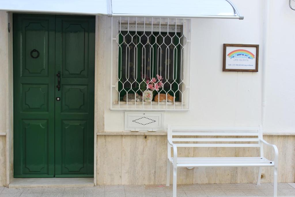 a green door and a bench in front of a building at Casa Vacanza Arcobaleno in Oria