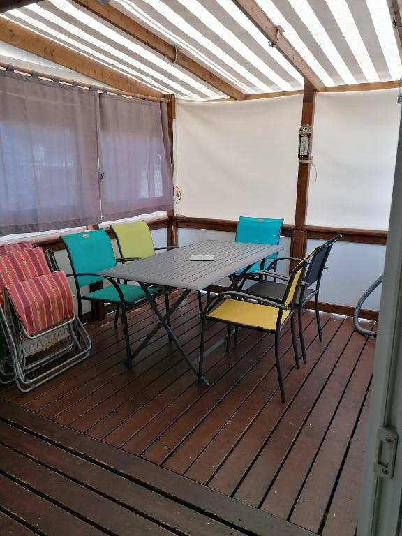 une table et des chaises sur le pont d'un bateau dans l'établissement Mobil home particulier dans camping La Chenaie, aux Mathes