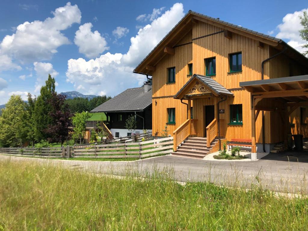 a large wooden building with a porch and stairs at Ausseer Chalet (nahe Hallstatt), Appartements in Bad Aussee