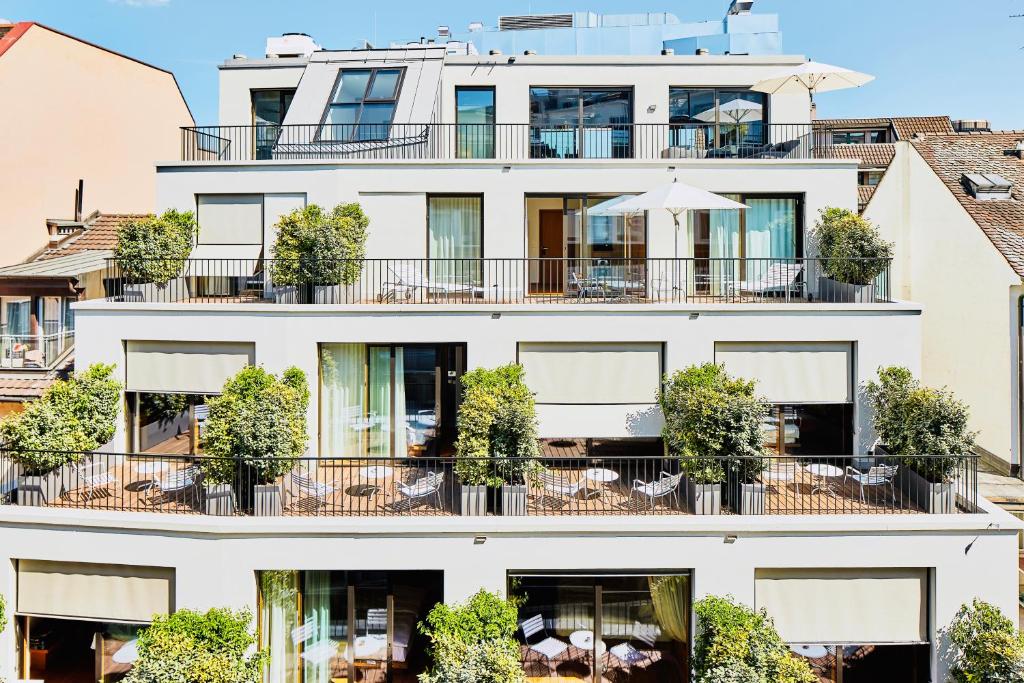 an apartment building with a balcony with tables and chairs at ART HOUSE Basel - Member of Design Hotels in Basel