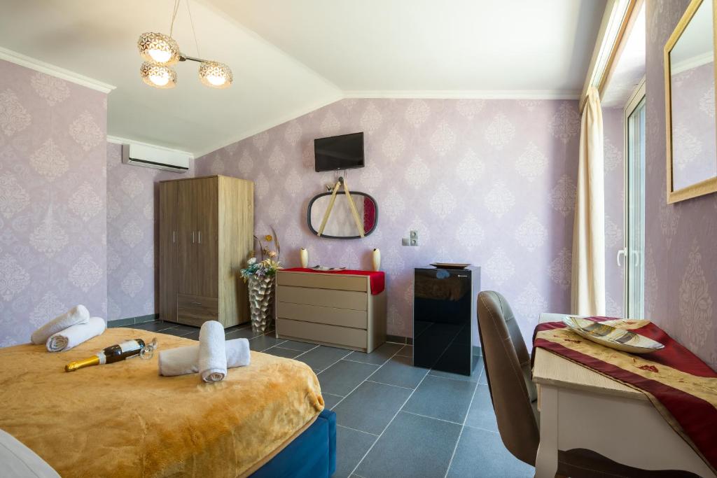 a bedroom with a bed and a desk and a room at Paradice Hotel Luxury Suites-Near zorbas Beach-FREE Breakfast in Stavros