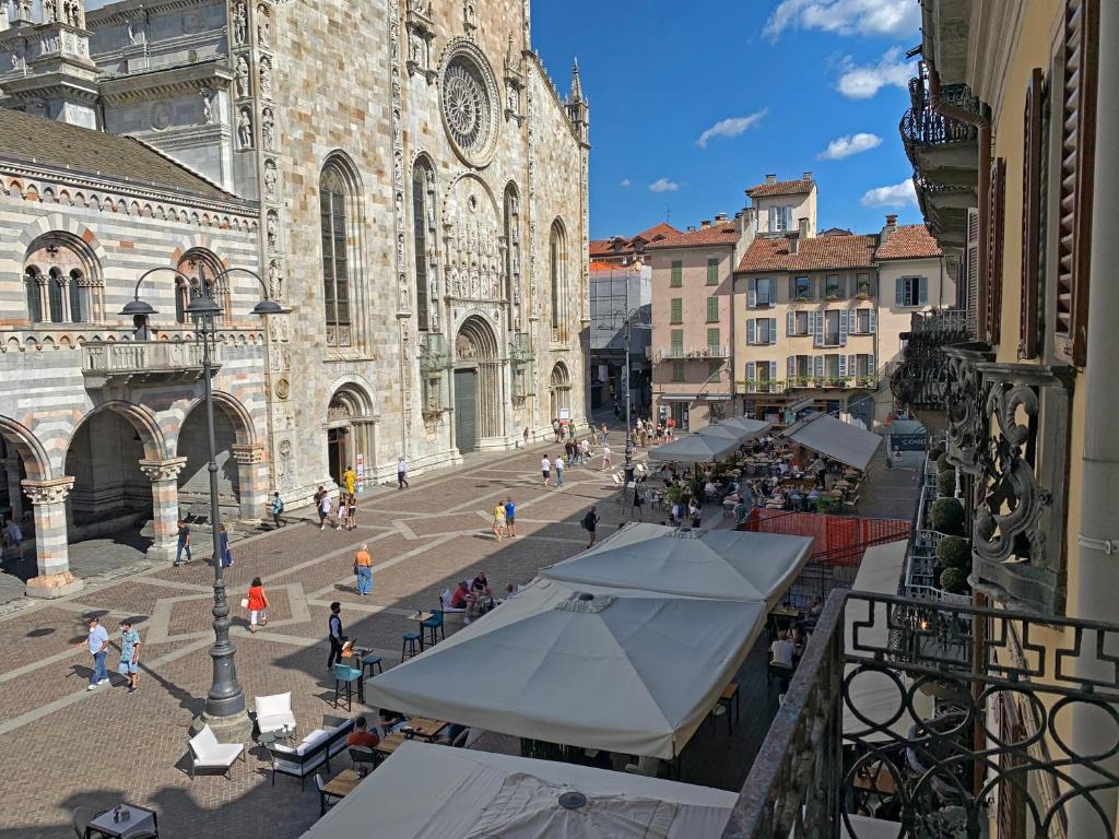 un groupe de personnes marchant dans une rue en face d'une église dans l'établissement Piazza Duomo Amazing Downtown By Como Vacanze, à Côme