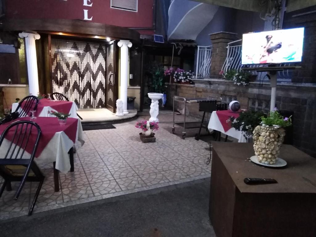 a restaurant with tables and a tv in a room at Hotel La Carina in Grottaminarda