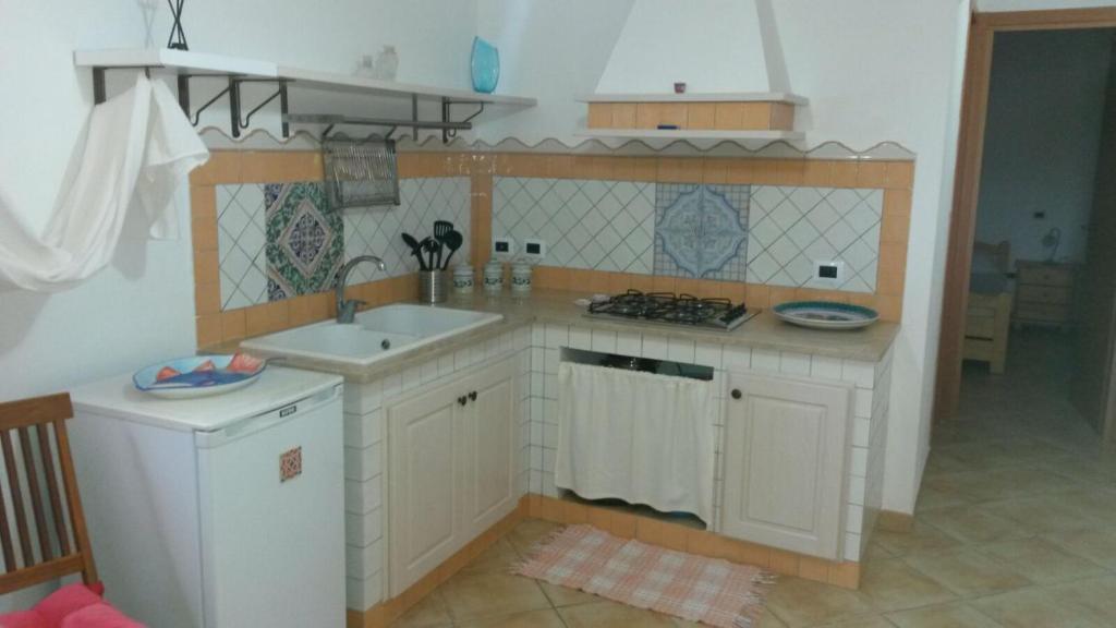 a small kitchen with a sink and a stove at Appartamenti Za Barbara in Lampedusa