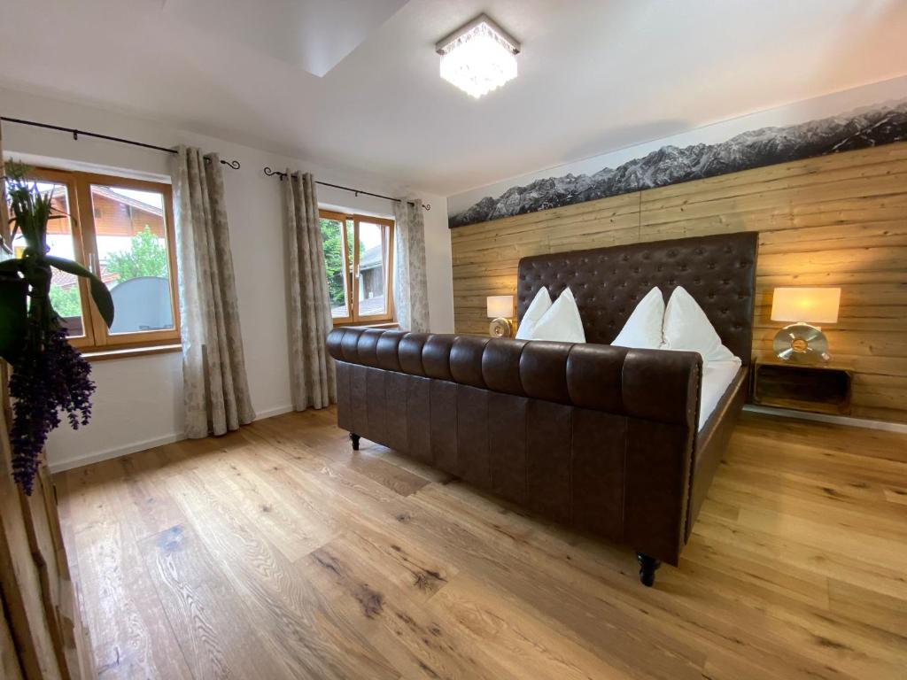 1 dormitorio con cama de cuero y pared de madera en Ferienwohnung Dolomiten en Nußdorf