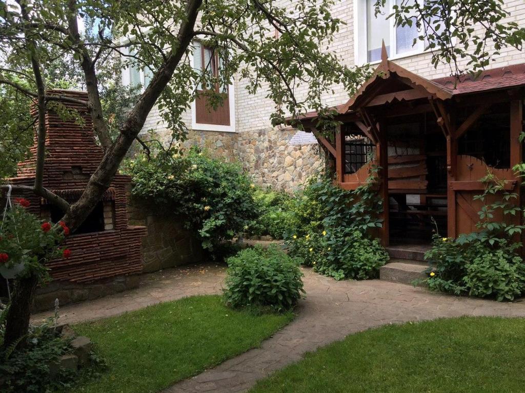 a brick house with a pathway leading to the front yard at Usadba Bilya Richky in Skole