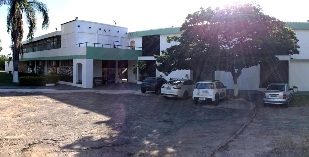 a house with cars parked in front of it at Hotel Nautico in Três Marias