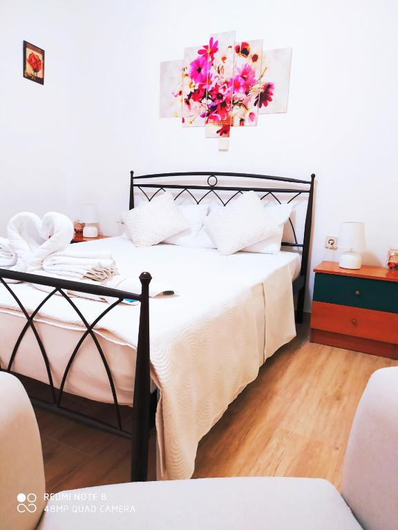 sypialnia z łóżkiem z ukwieceniem w obiekcie Cofineta Apartment w Korfu