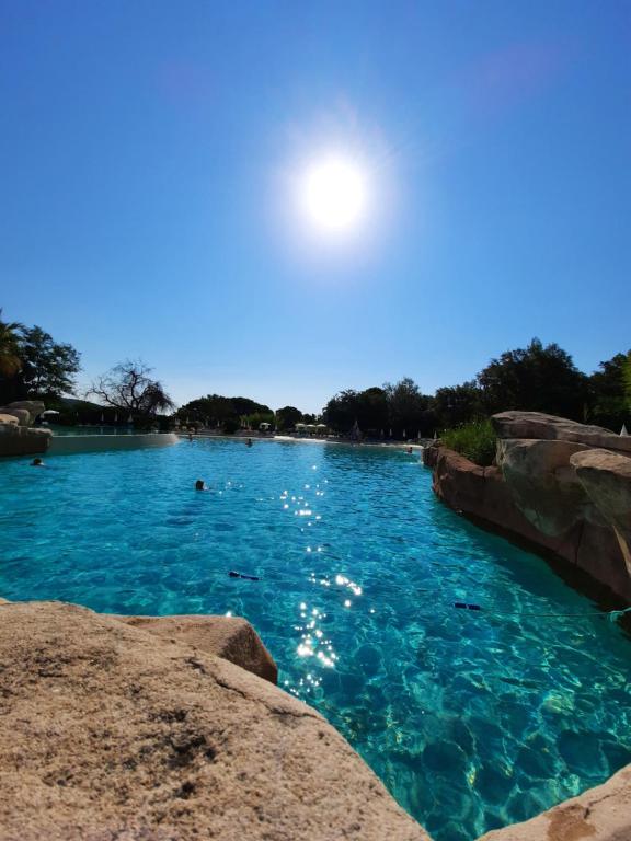 une piscine d'eau bleue avec des gens qui y nagent dans l'établissement Les Restanques - Grimaud, à Grimaud