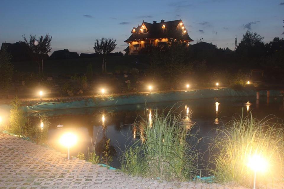 una casa sentada en la cima de un lago por la noche en Colorado Podhale en Skawa