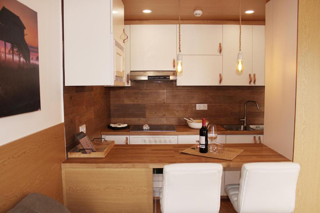 a kitchen with white cabinets and a table with white chairs at Aloe Friendly Holiday Home in Playa del Ingles