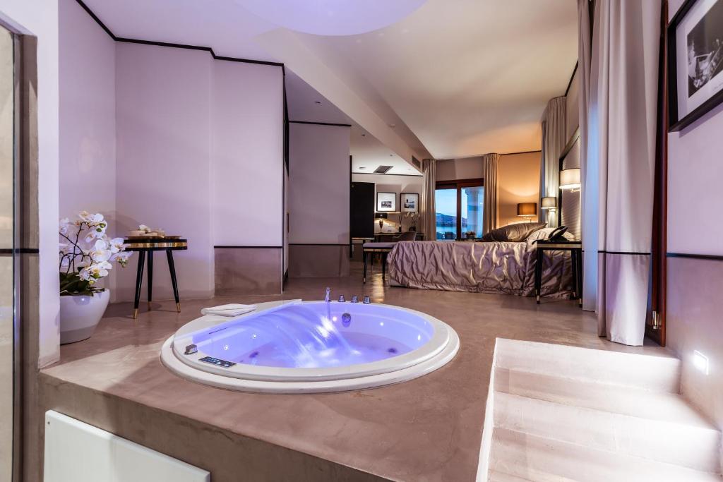 uma grande casa de banho com banheira no meio de um quarto em La Locanda Del Conte Mameli em Olbia