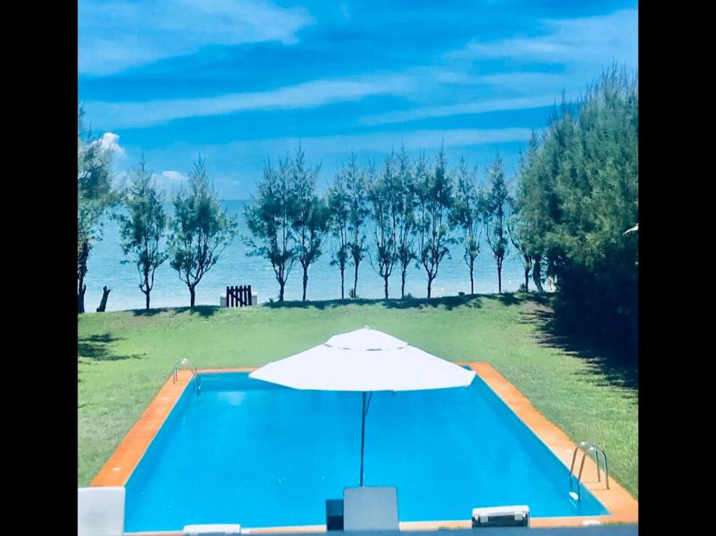 uma piscina com um guarda-sol junto à água em Luxury Villa Casa do Sol em Búzios