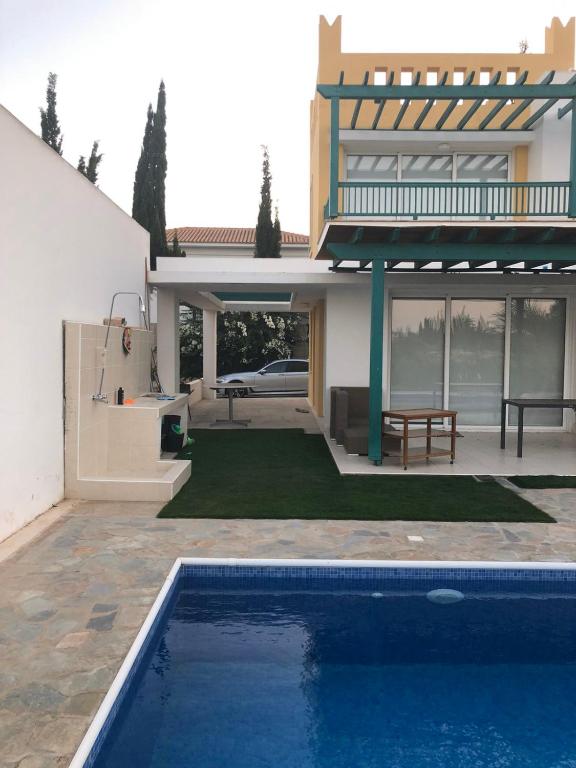 a house with a swimming pool in front of a house at Oasi Rejuve Poseidon in Meneou