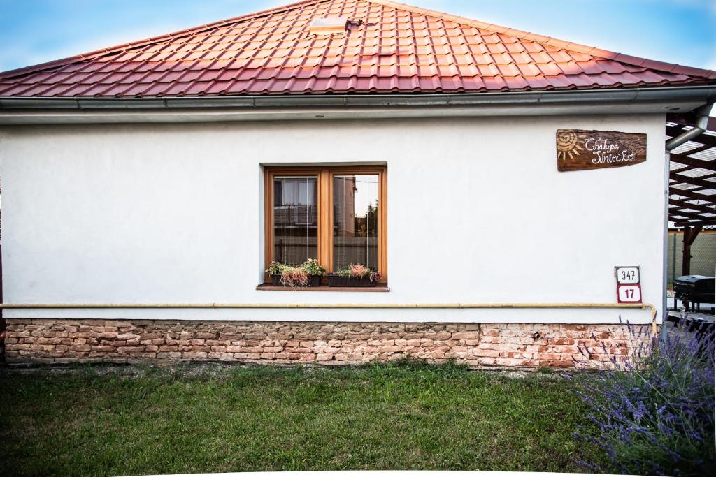Casa blanca con techo rojo y ventana en Chalupa Slniečko, en Dolný Ohaj