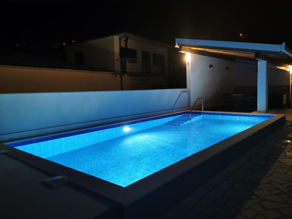 uma piscina num quintal à noite em Apartmani "Allegro" em Podaca