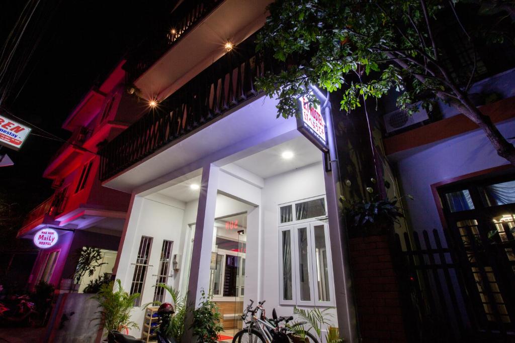 Ein weißes Gebäude mit einem Schild in der Nacht. in der Unterkunft 5.T Hostel in Hue