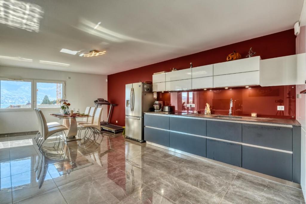 a kitchen with red walls and blue cabinets and a table at le panorama du lac in Annecy