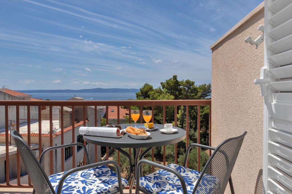 a table and chairs on a balcony with a view of the ocean at Penzión Slovan in Tučepi