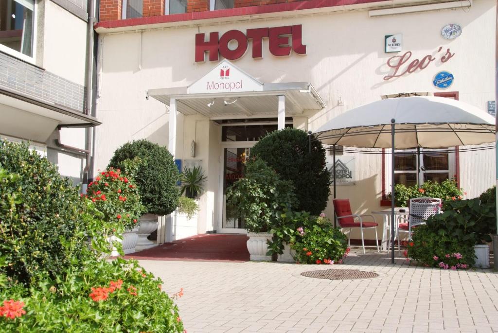 un hôtel avec une table et un parasol devant lui dans l'établissement Hotel Monopol, à Gelsenkirchen