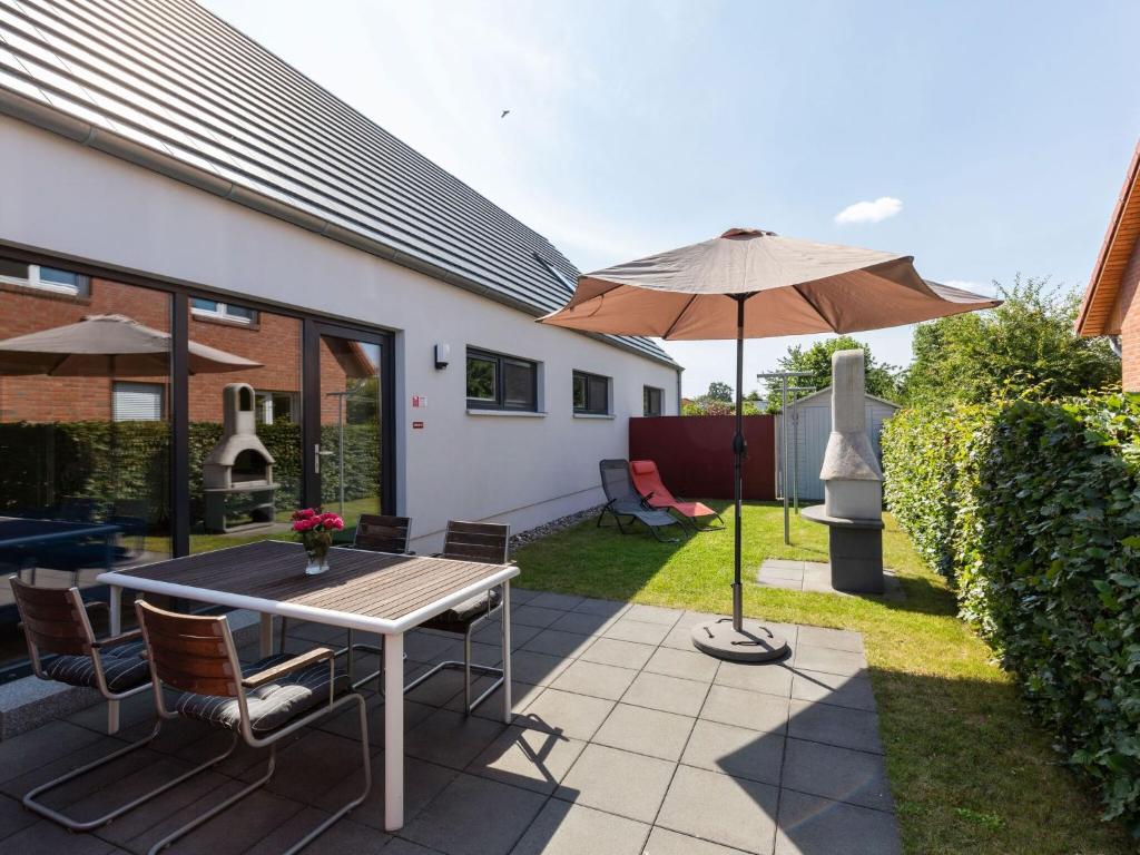 a patio with a table and an umbrella at Delightful Holiday Home in Zierow near Seabeach in Zierow