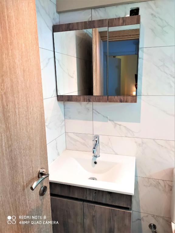łazienka z umywalką i lustrem w obiekcie Cofineta Apartment w Korfu