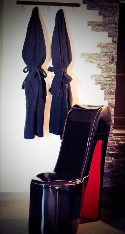 a black chair with a red high heel and a robe at Loft 47 Spa in Chambly
