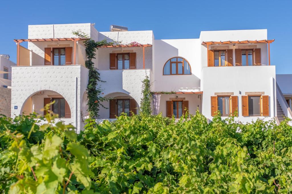 uma fachada de um edifício com vegetação verde em Stefanos Studios em Skala