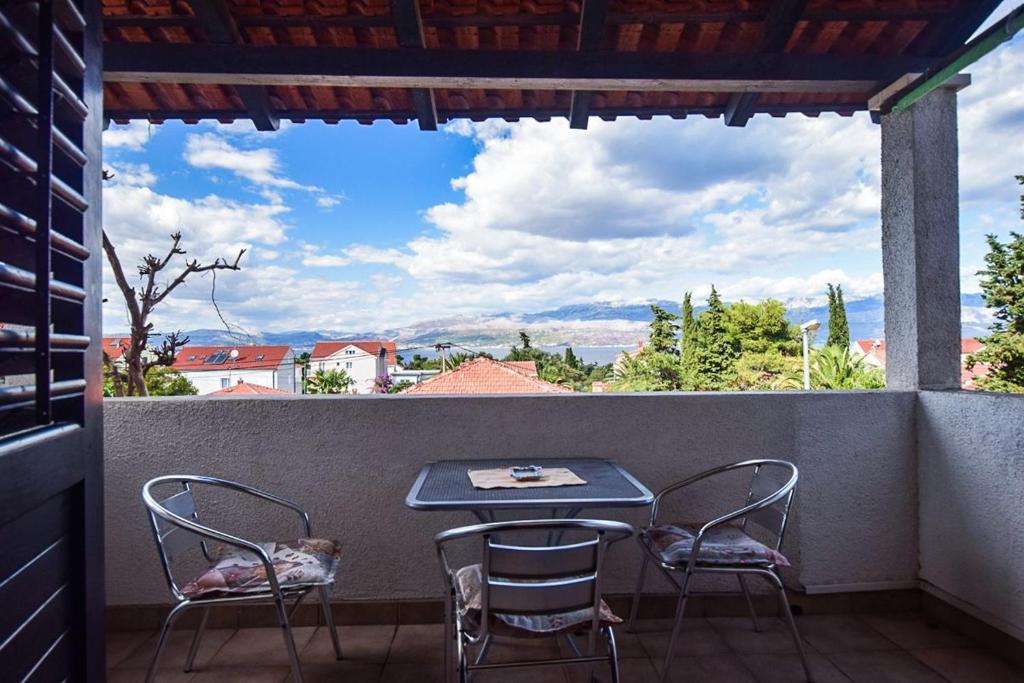 a table and chairs on a balcony with a view at Apartments Derado in Supetar
