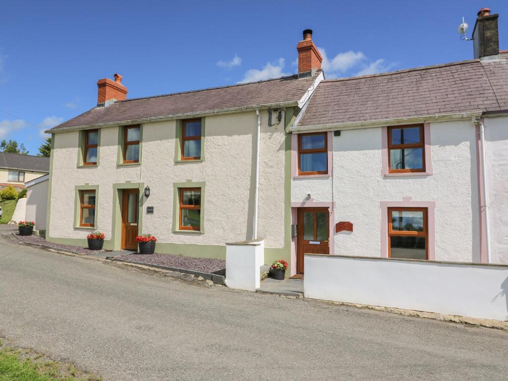 een wit huis aan de kant van een weg bij Bank House in Newcastle Emlyn