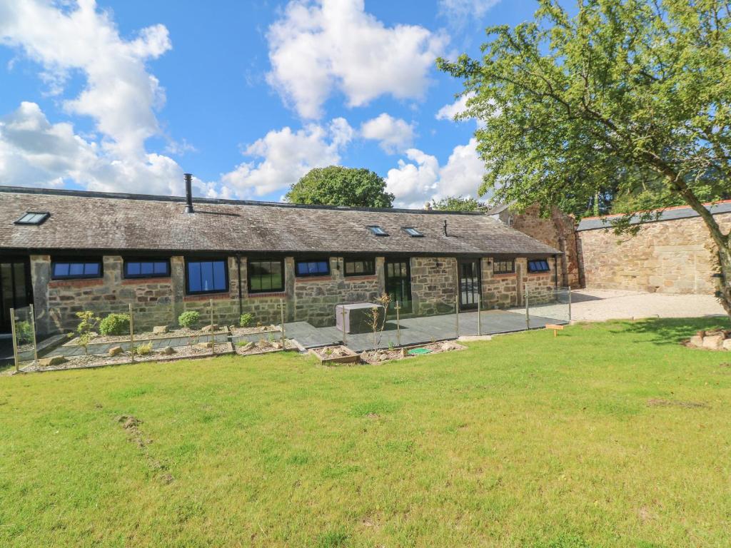 un vecchio edificio in pietra con un cortile di fronte di Nana's Cottage a Camborne