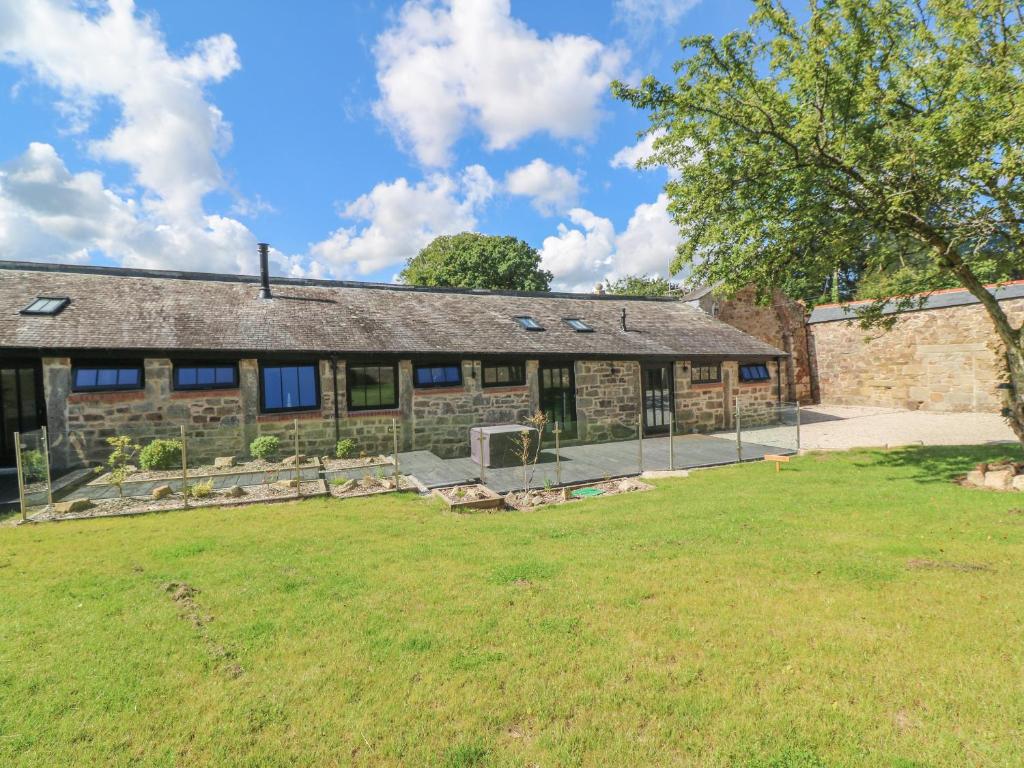 an old stone building with a yard in front of it at Nana's Cottage in Camborne