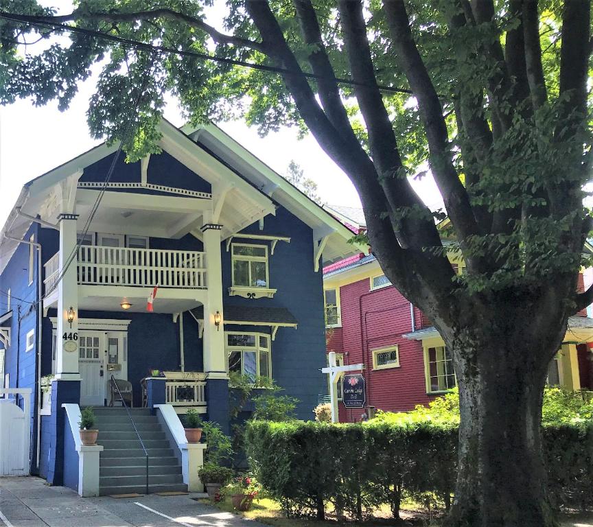 ein farbenfrohes Haus mit einem Baum davor in der Unterkunft Cambie Lodge in Vancouver